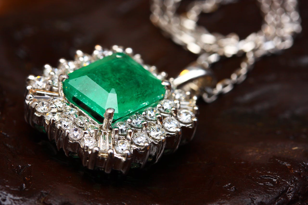 our-services-2 Stunning emerald pendant necklace in white gold with shimmering diamonds, epitomizing luxury and elegance.