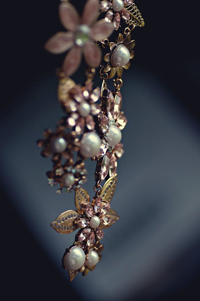 about-01 Close-up of a luxurious floral necklace featuring pearls and gemstones with a vintage charm.